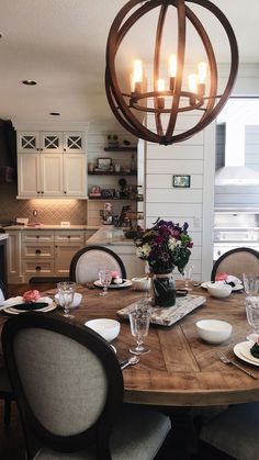 a dining room table is set with place settings for six people and the lights are turned on