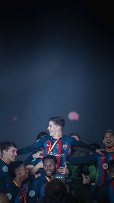 a group of men standing around each other in front of a crowd holding a trophy