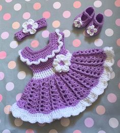 a crocheted baby dress and booties on a polka dot blanket