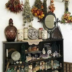 a shelf filled with lots of bottles and vases next to a wall mounted mirror