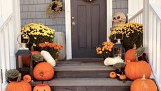 pumpkins and gourds are sitting on the front steps