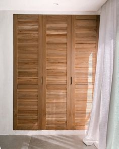 an empty room with wooden shutters on the doors