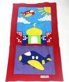 a child's play mat with an airplane and building scene on the front side