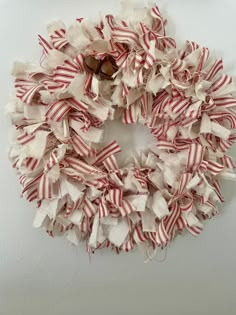 a red and white striped wreath hanging on the wall next to a wooden door handle