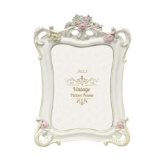 an ornate white frame with pink flowers on the edges and gold lettering that reads vintage picture frame