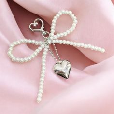 Add a touch of elegance to your accessories with this coquette-style metal heart keychain featuring a beaded charm and a delicate white bow. Perfect for styling your bag, phone, or AirPods, this keychain offers a charming and feminine touch to any look. The combination of the sleek metal heart and the soft bow creates a beautiful contrast, while the beaded accents add a unique flair. Whether as a gift or a personal accessory, this keychain is ideal for coquette fashion lovers who want to express Keychain Beaded, Coquette Fashion, Motifs Perler, Coquette Style, Heart Keychain, Metal Heart, White Bow, Personalized Accessories, Bead Designs