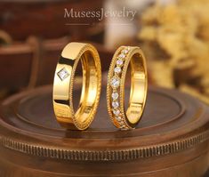 two gold wedding bands with diamonds on top