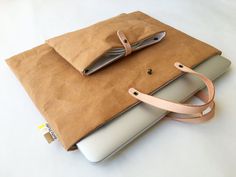 an open laptop computer sitting on top of a brown bag