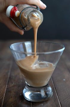 someone pouring something into a small glass bowl