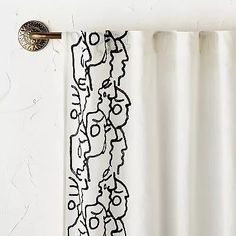 the curtain is drawn with black ink on white paper and hangs in front of a wall