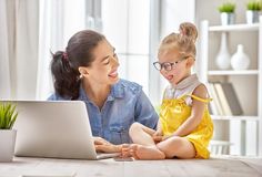 a mother and her daughter are sitting on the floor in front of a laptop