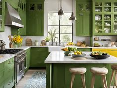 a kitchen with green cabinets and white counter tops, yellow accents on the counters and stools