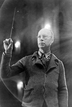 an old black and white photo of a man holding a wand