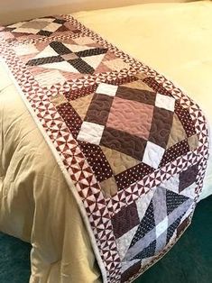 a bed with a quilt on top of it