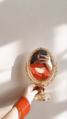 a person holding up a mirror with their hand