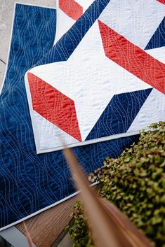 two quilts with red, white and blue designs on them sitting next to each other