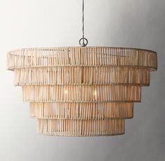 a chandelier made out of bamboo sticks and hanging from a ceiling light fixture