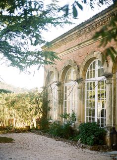 an old building with many windows and plants