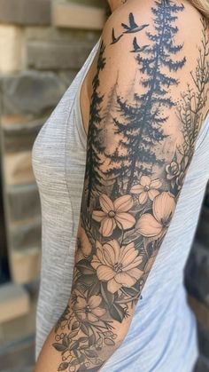 a woman with a tree and flowers tattoo on her arm