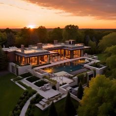 an aerial view of a house at sunset with the sun setting in the background and trees surrounding it