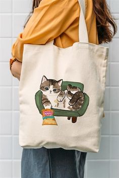 a woman holding a tote bag with a cat on it