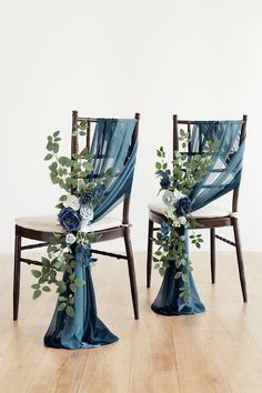 two chairs decorated with blue flowers and greenery