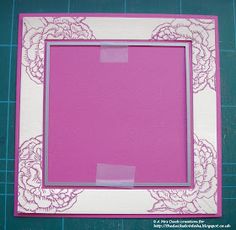 a pink and white frame sitting on top of a cutting board