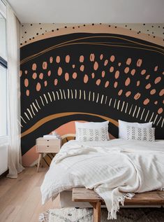 a bedroom with black and orange wallpaper, white bedding and wooden flooring