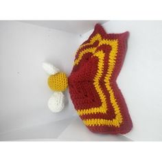 a crocheted bag with a yellow and red design next to a white flower