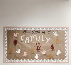 a bulletin board that says our class is a family with handprints on it