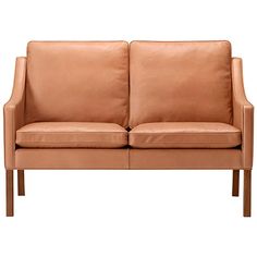 a tan leather couch sitting on top of a wooden frame