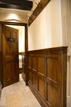 two wooden doors are open in a hallway