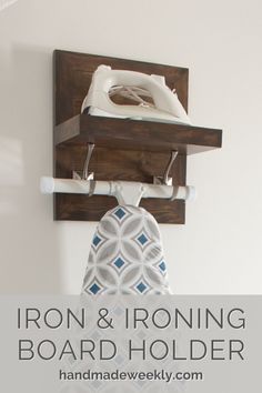 an iron and ironing board holder is mounted on the wall above a toilet paper dispenser