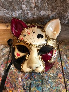 "Exclusive cat mask decorated with poker cards and bright colors. Ideal for carnival parties. Original hand-painted Venetian mask embellished with decoration with stucco and non-toxic acrylic colors. -Material/Resin Made in Italy hypoallergenic and non-toxic. -Dimensions/18x18 Unisex -History of the mask / a double legend intertwines the fate of this mask of the appearance of a cat. From ancient texts it would be a \"Sacred\" animal for the city of Venice because it would have saved it from the Carnival Parties, Mask Cat, Venice Mask, Venetian Carnival Masks, Venetian Carnival, Clown Mask, Carnival Mask, Acrylic Colours, Costume Masks