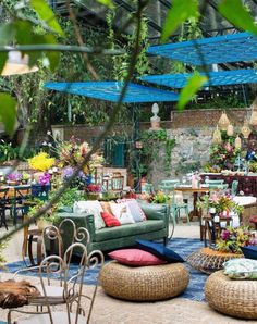 an outdoor seating area with wicker furniture and flowers on the tables in the background