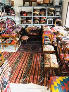 a room filled with lots of colorful rugs and wooden chairs next to each other