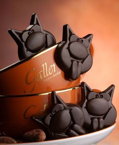 the chocolates are shaped like black cats and have been placed on top of each other