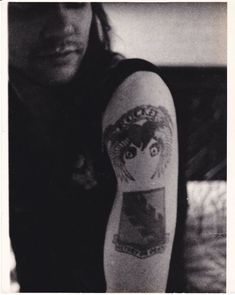 black and white photograph of a woman's arm with tattoos on it