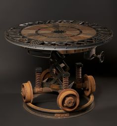 an old wooden table with wheels on the bottom and one wheel attached to the base