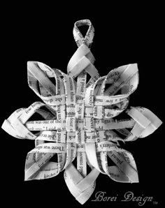 an origami snowflake made out of newspaper strips with words written on it