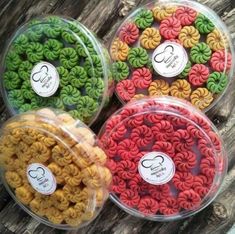 three plastic containers filled with different types of macaroni florets on top of a wooden table