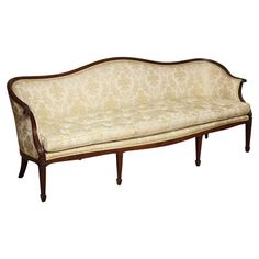 an old style couch with wooden frame and upholstered fabric