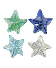 four glass stars in different colors on a white background