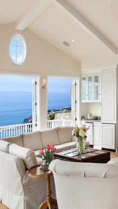 a living room filled with furniture and large windows