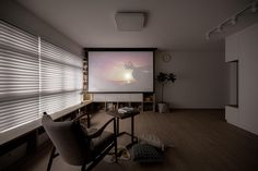 an empty room with a projector screen in the corner