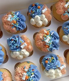 many cupcakes are decorated with blue and white icing