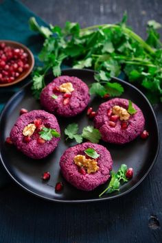 some food is on a black plate and garnished with pomegranate