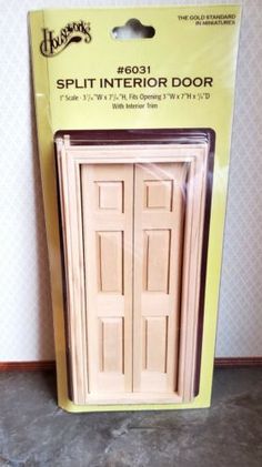 a pair of wooden doors sitting on top of a floor next to a package of cardboard