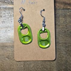 pair of green earrings sitting on top of a piece of cardboard