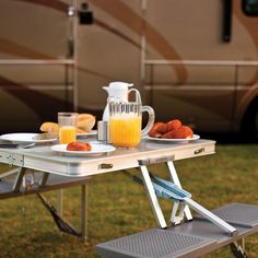 a table with food and drinks on it in front of a motor home